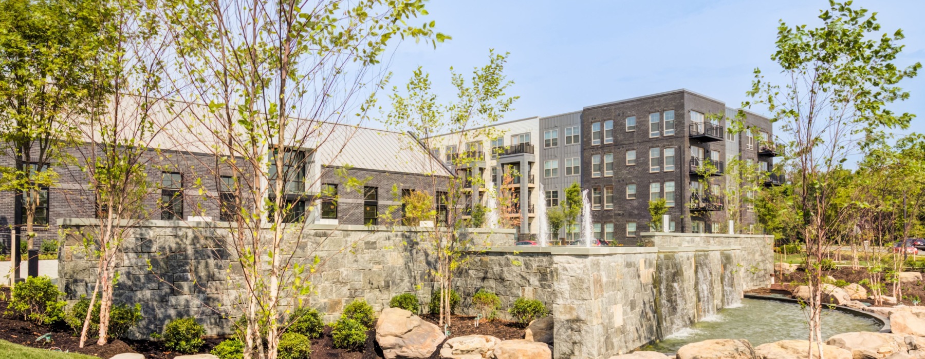 entrance water feature with trees and plants EDE luxury apartments Frederick MD