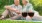 a couple sitting on the grass with wine glasses - EDE Frederick MD brand new apartments